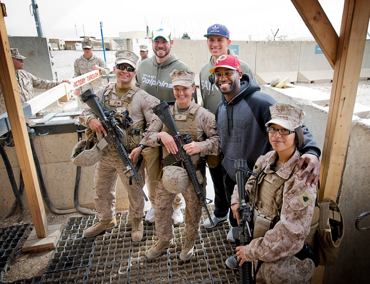 From left to right, NFL stars Brandon Fields, Jimmy Graham and Pierre Garcon pose for a photo with troops during their USO tour to the Middle East in March. USO photo by Dave Gatley