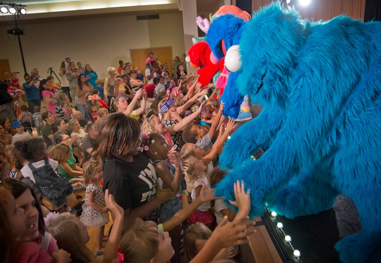 The cast of the Sesame Street/USO Experience for Military Families shakes hands with young audience members. USO Photo by Dave Gatley
